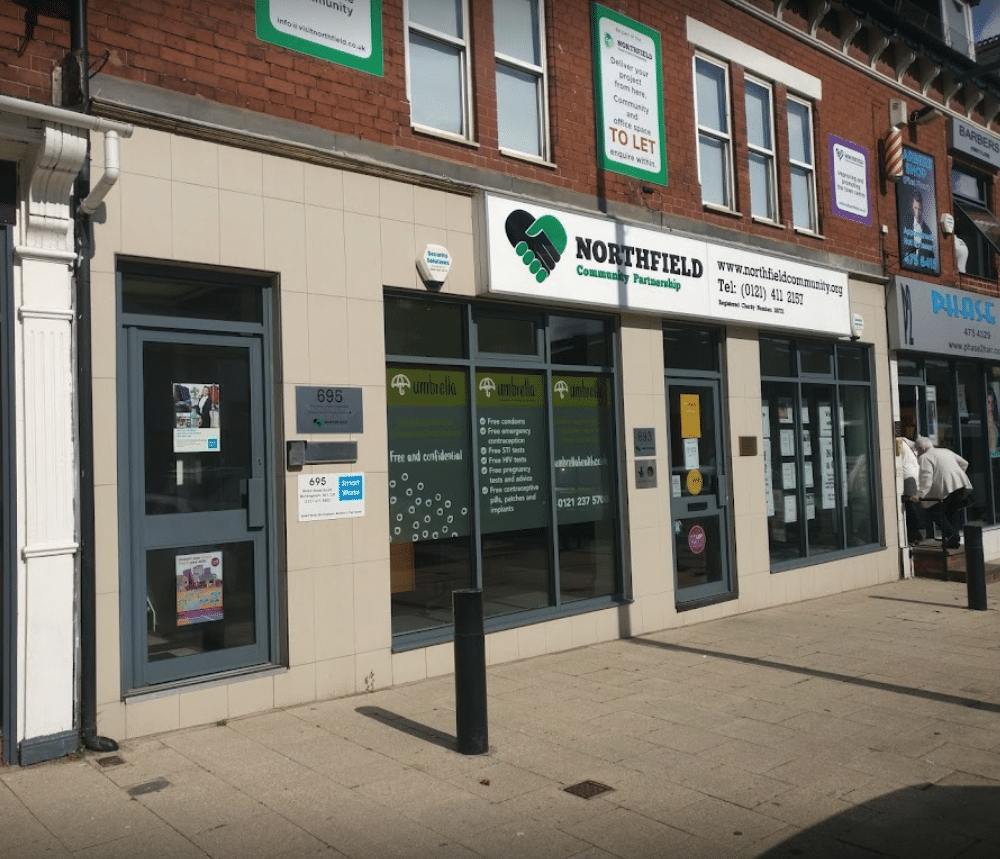 Light grey building with a sign for 'Northfield Community Partnerhsip' by the front.